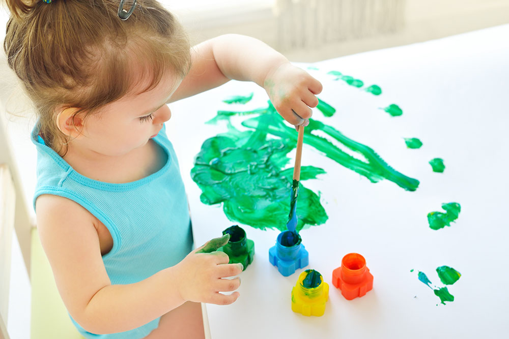 young girl painting in class at a Preschool & Daycare Serving New Braunfels, TX