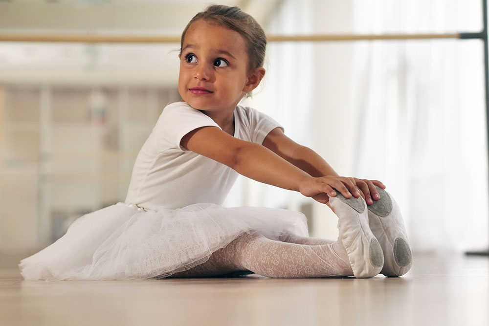 young smiling girl doing ballet at a Preschool & Daycare Serving New Braunfels, TX