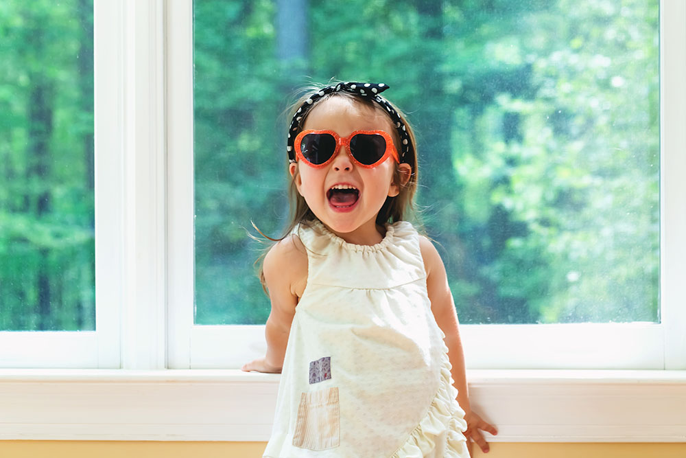 Happy toddler girl wearing sunglasses at a Preschool & Daycare Serving New Braunfels, TX