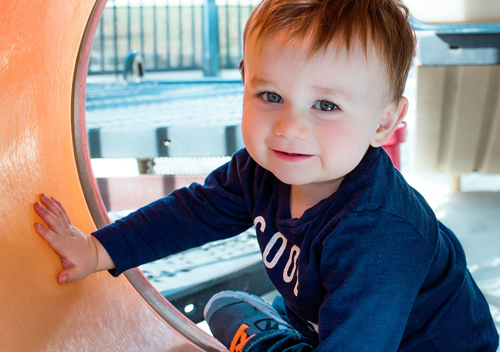 Toddler boy playing on playground at a Preschool & Daycare Serving New Braunfels, TX