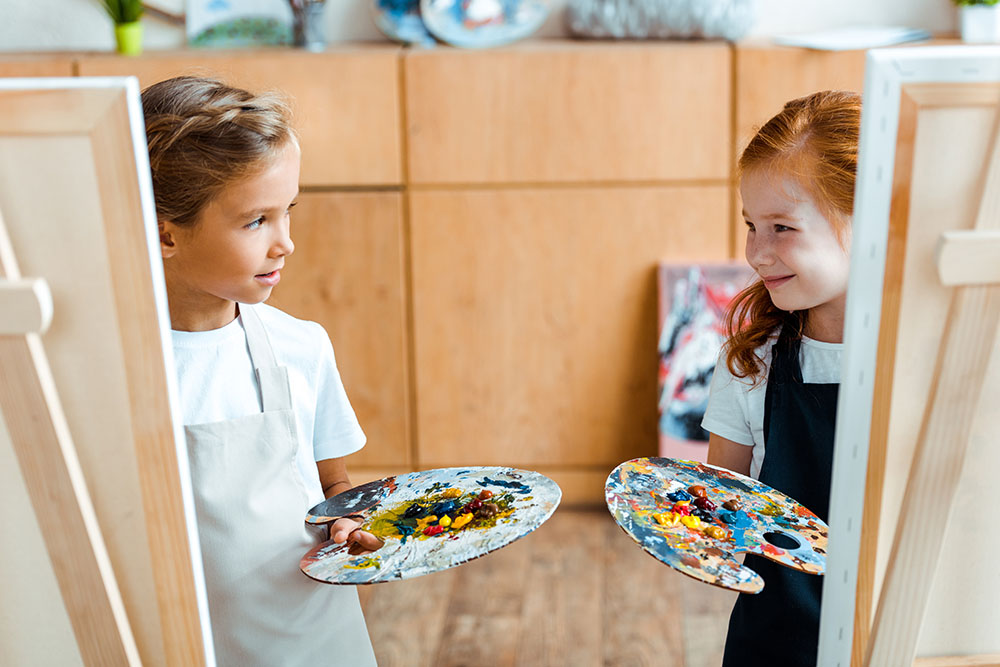 kids holding colorful palette at a Preschool & Daycare Serving New Braunfels, TX