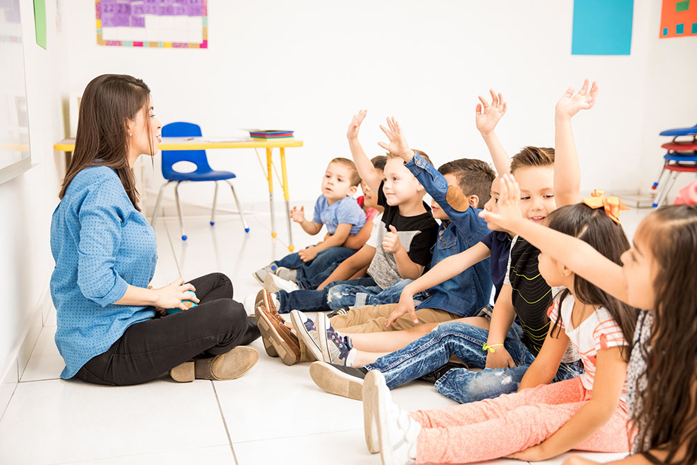 students raising their hands at a Preschool & Daycare Serving New Braunfels, TX