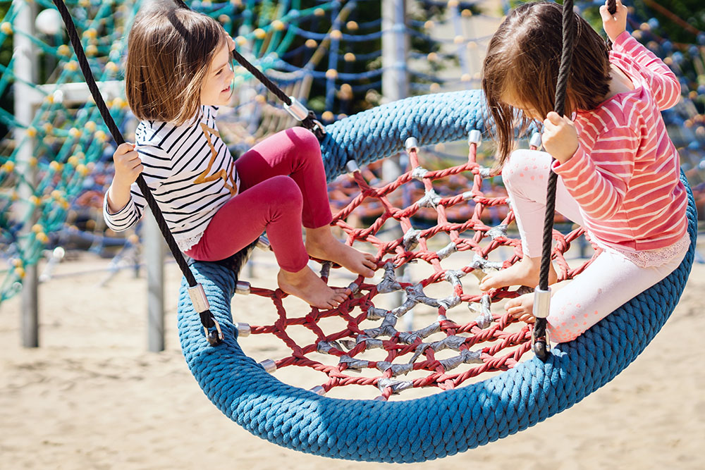 two little girls on swing at a Preschool & Daycare Serving New Braunfels, TX