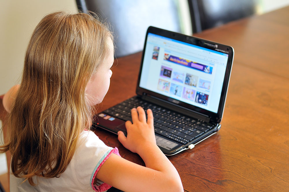 young girl with computer at a Preschool & Daycare Serving New Braunfels, TX