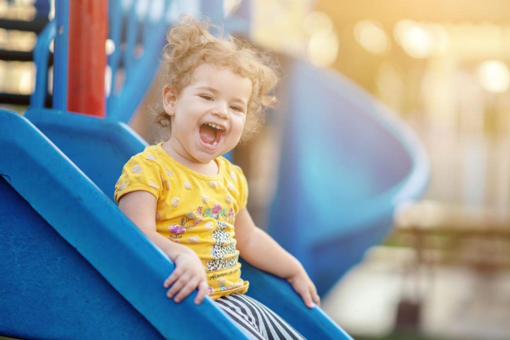 Little Toddler Playing At Playground Outdoors In Summer at a Preschool & Daycare Serving New Braunfels, TX